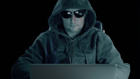 adult caucasian man in hoody sweatshirt and glasses sits with computer and surf internet late night at concrete background. alpha channel chroma key transparent background.