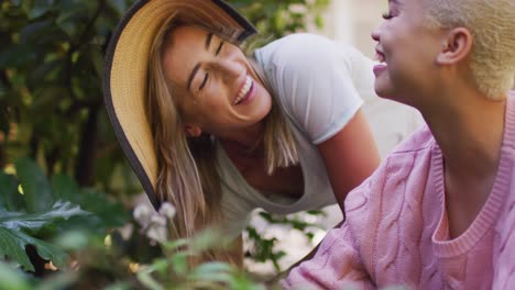 Happy-diverse-female-couple-working-on-sunny-day-in-garden