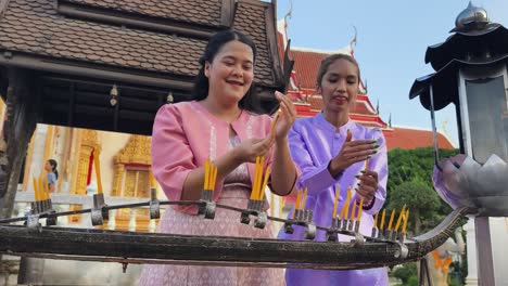 women praying at a temple in thailand