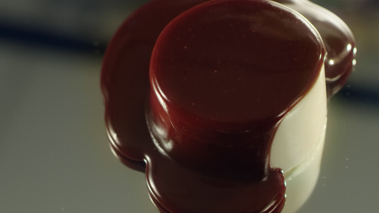 una corriente de chocolate oscuro se extiende sobre la superficie del pastel.