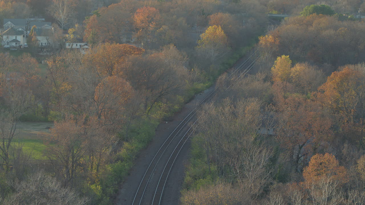 11월의 예쁜 가을날 커크우드 인근 주택 근처의 가을 나무를 가로지르는 기차 선로의 공중