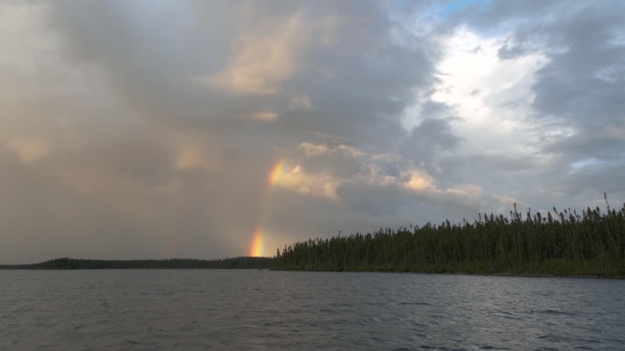 magnífico cielo sobre un lago con un arco iris atravesando las nubes
