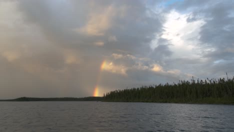 Magnífico-Cielo-Sobre-Un-Lago-Con-Un-Arco-Iris-Atravesando-Las-Nubes