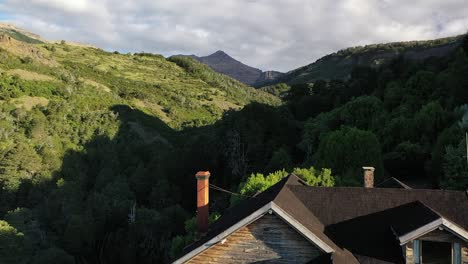 flying up from wood and stone house in middle of vegetated mountains recorded in slow motion 60fps