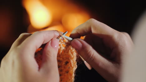 noche junto a la chimenea antes de navidad - una mujer teje ropa de abrigo 4k video