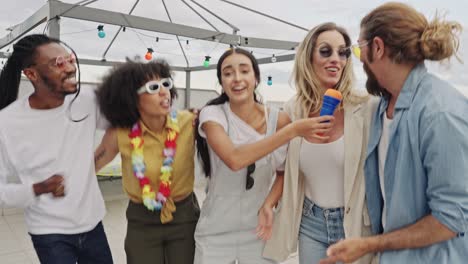 friends having fun at a rooftop karaoke party