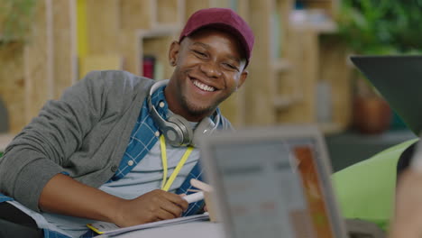 close up young african american businessman smiling happy enjoying creative teamwork sharing ideas with colleagues in successful startup office