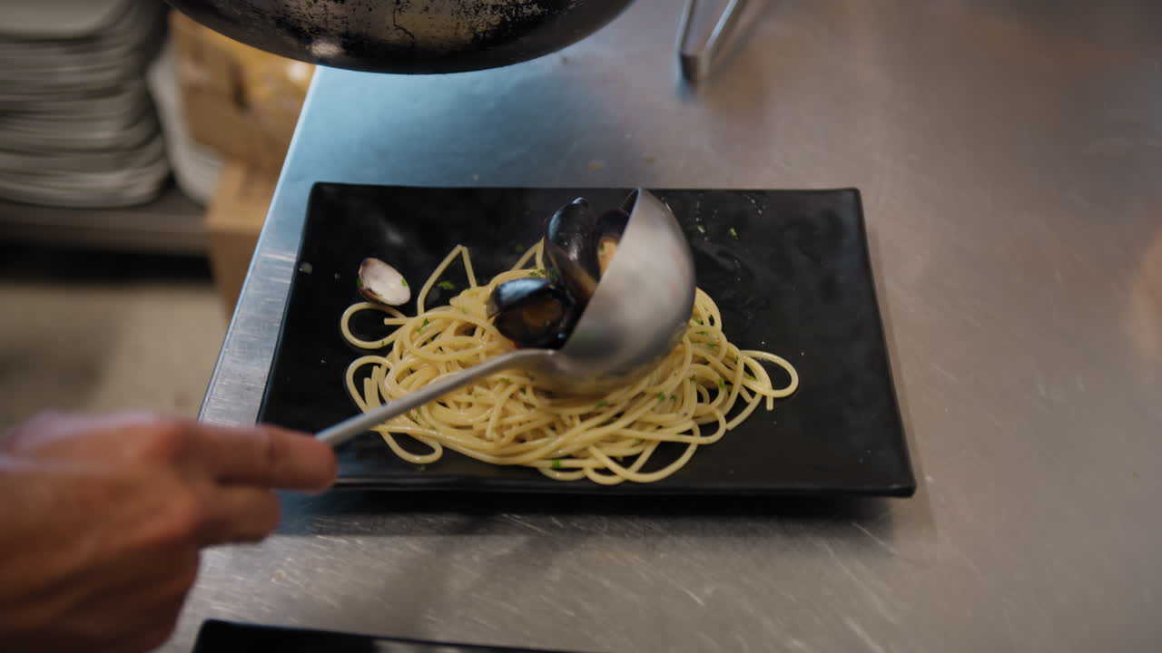 Chef Plating A Gourmet Dish Of Spaghetti With Mussels