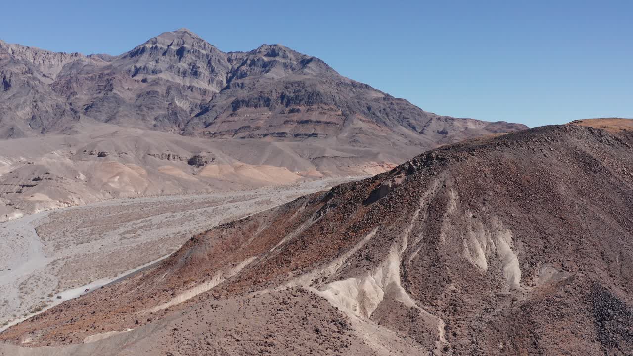 Aerial low shot flying over a rocky ridge in the desert landscape of ...