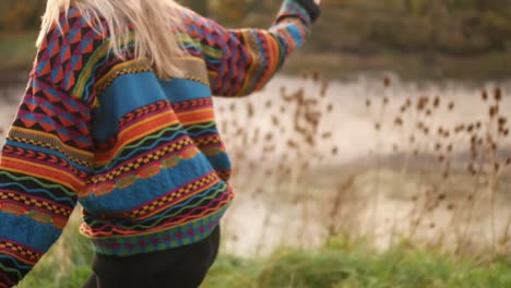 mujer con suéter colorido caminando de manera infantil