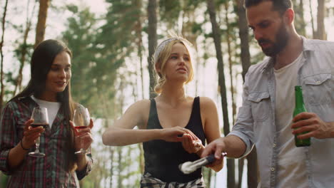 focused friends cooking food together outside. smiling woman keeping salt