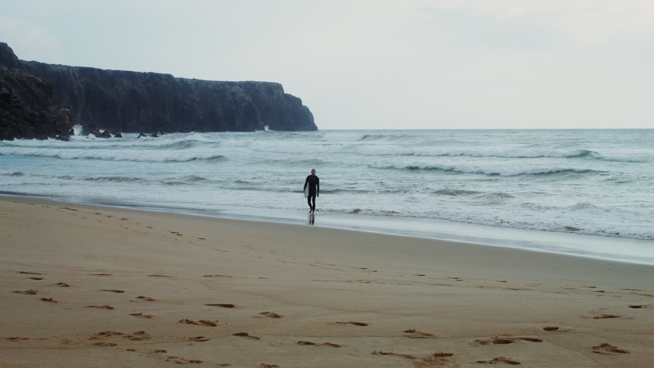 surfista caminando por la playa