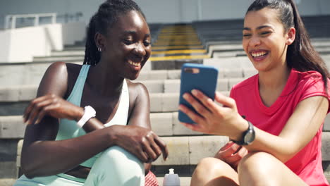 Female-athletes-laughing-while-looking-at-a-funny