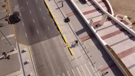 toma aérea de un ciclista montando en la calle costera de mar del plata al lado de la playa durante el día soleado