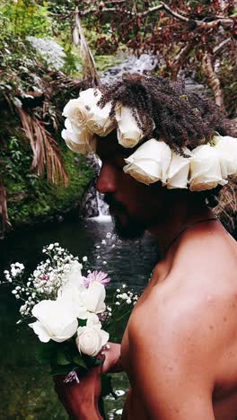 hombre con corona de rosa junto a la cascada