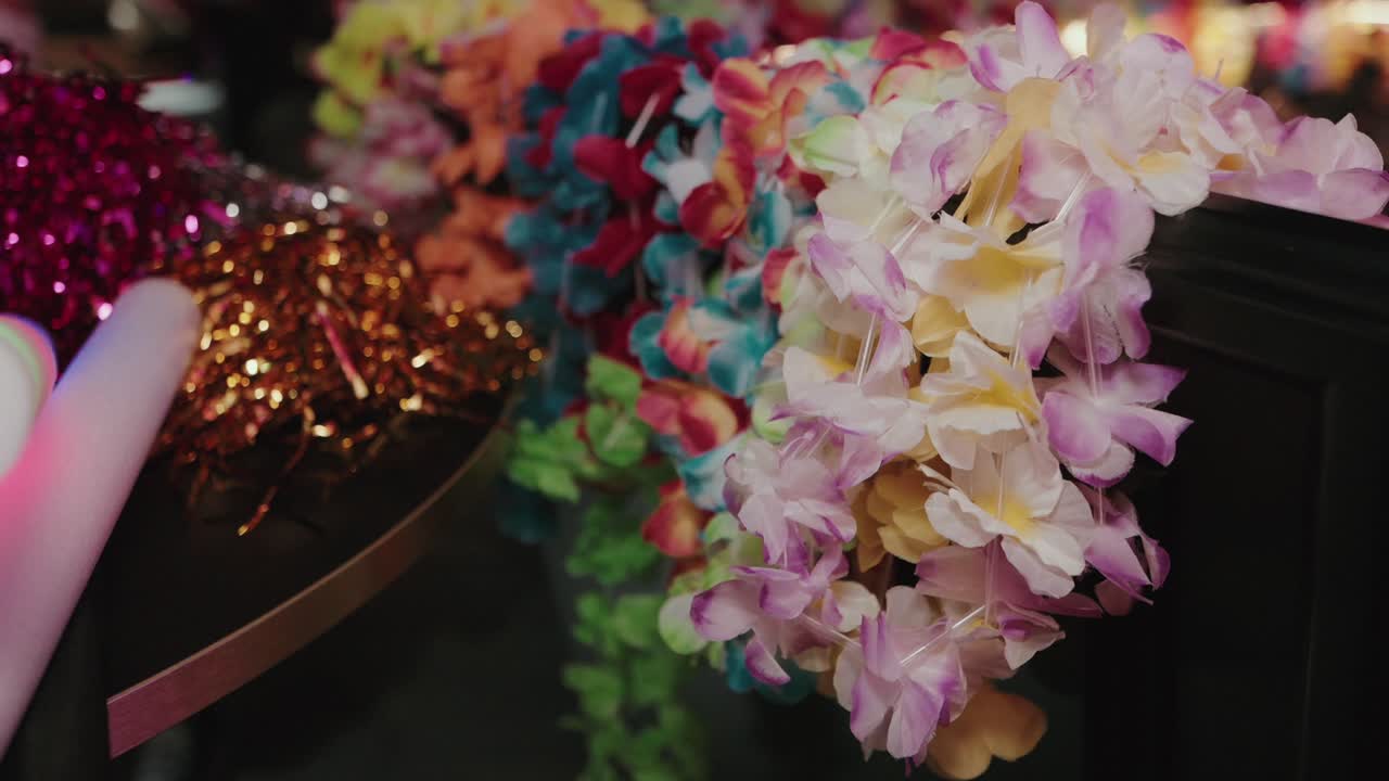 colorful flower leis and glittery tinsel on party table indoors