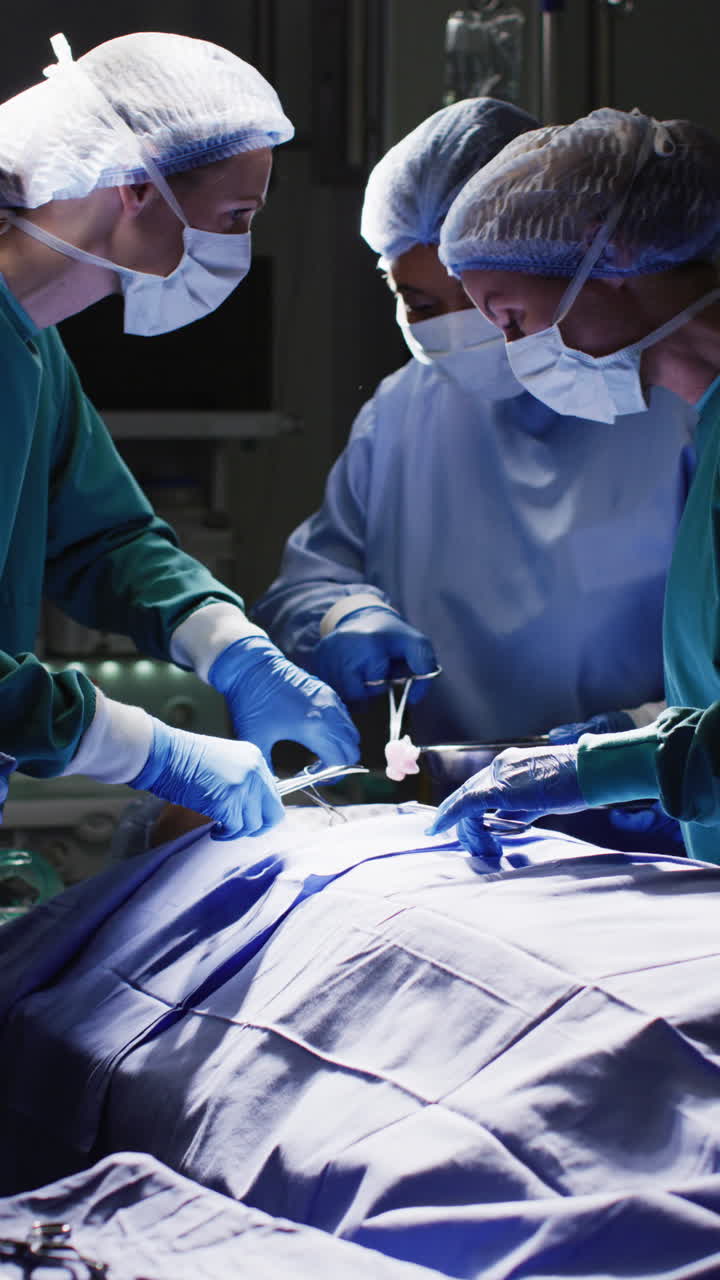 Vertical video of diverse surgeons with face masks during surgery