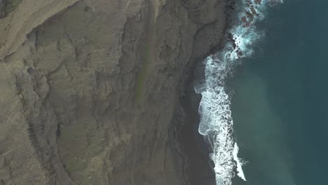 Drone-top-down-shot-of-waves-bounce-on-rocks-at-the-coast