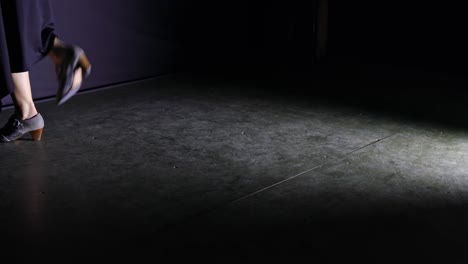 dramatic scene of woman in black dress dancing flamenco on stage. handheld