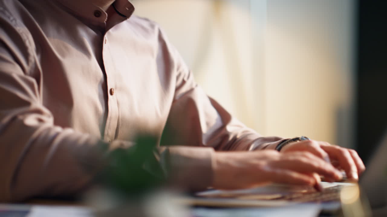 Geconcentreerde werknemer typt en drinkt koffie op werkplek, close-up. Schrijver aan bureau.