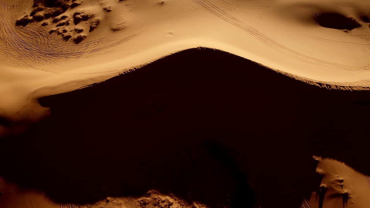 From a bird’s-eye perspective, a drone reveals pink sand dunes shaped by wind and color in southern Utah.