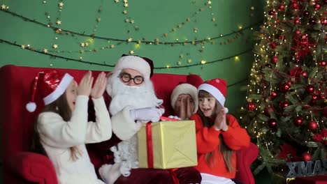 Santa Claus Gives Presents to Small Children Christmas Holiday Santa Claus with a Group of Children in the United States Holding Gifts in their Hands Happy Children