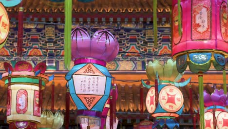 chinese lanterns, which symbolize prosperity and good fortune, hang from ceiling wires next to a temple during the mid-autumn festival, also called mooncake festival