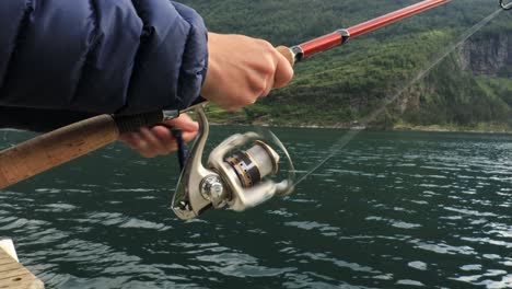 woman fishing on fishing rod spinning in norway.