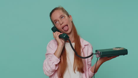 crazy teenager girl child kid talking on wired vintage telephone of 80s, fooling making silly faces