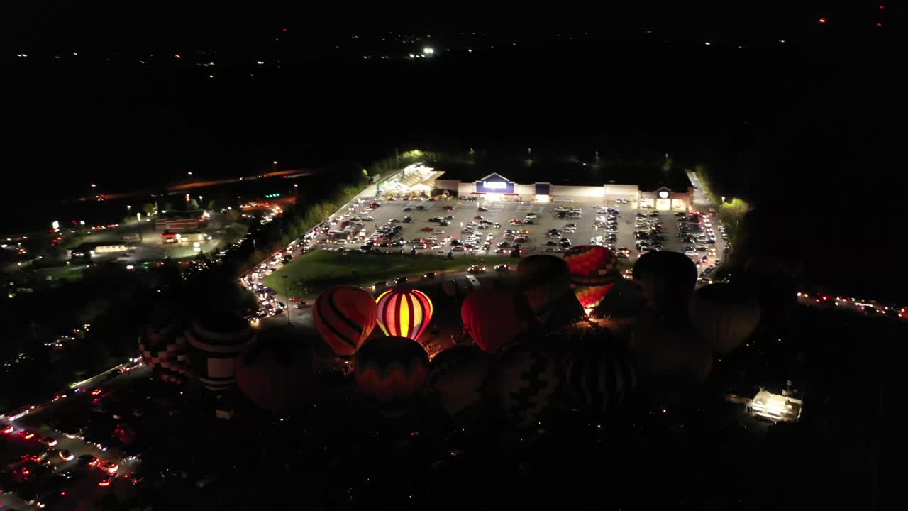 globos de aire caliente se iluminan durante la noche en un parque de atracciones, en west virginia, ee.uu.