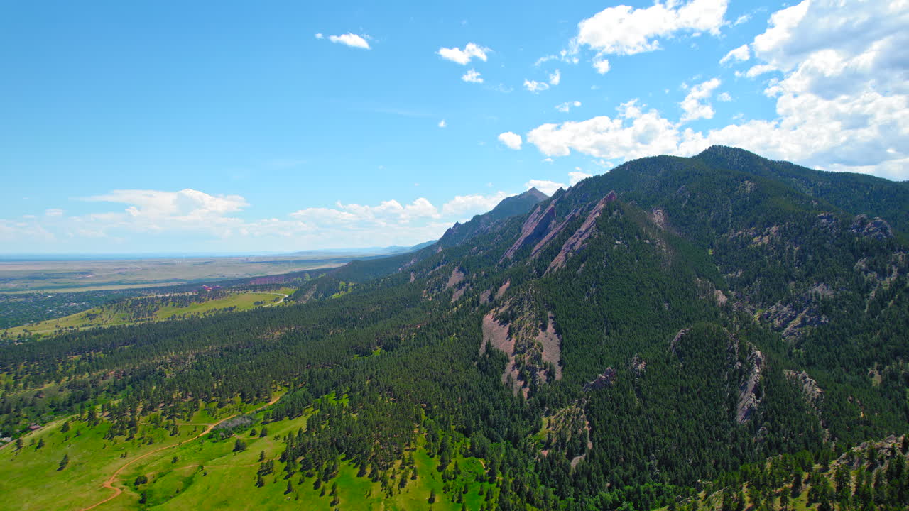 imágenes de drones aéreos escénicos de 4k del paisaje del bosque montañoso alpino durante el verano cubierto de pinos verdes con un hermoso cielo azul y nubes blancas hinchadas