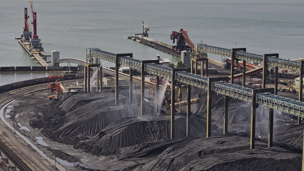 Newport News Virginia Aerial v3 zoomed flyover Dunbar's shipping terminal capturing conveyors and dust suppression systems misting over massive coal piles - Shot with Mavic 3 Pro Cine - Sept 30th 2023