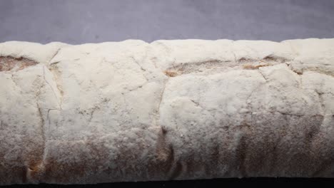 Freshly-baked-baguette-on-black-background,-top-view