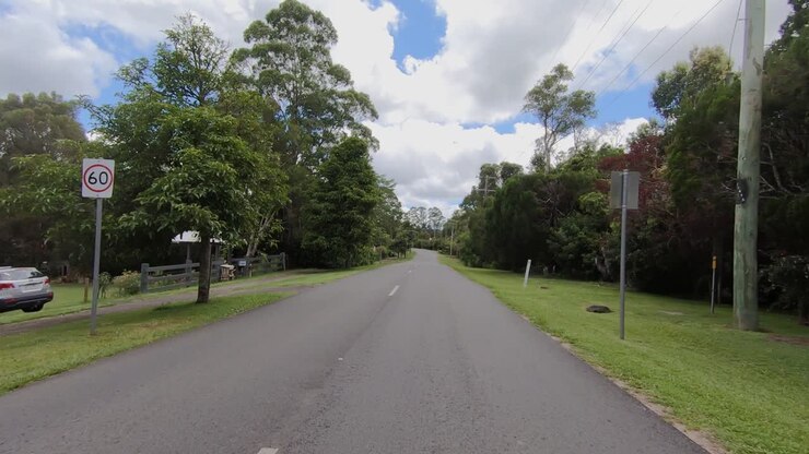 Rear facing driving point of view POV of a deserted Queensland country road in Sunshine Coast hinterland - ideal for interior car scene green screen replacement