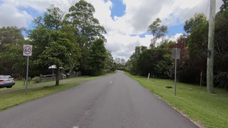 rear facing driving point of view pov of a deserted queensland country road in sunshine coast hinterland - ideal for interior car scene green screen replacement