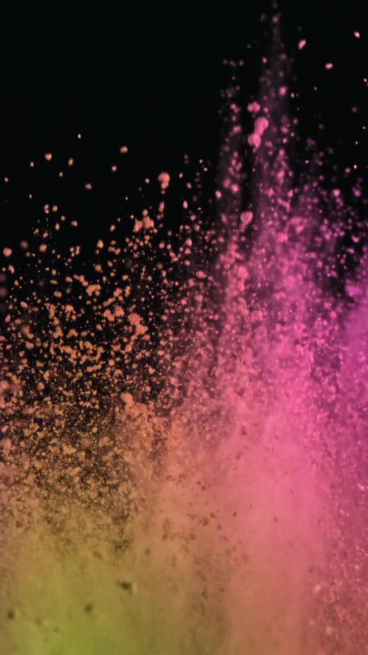 Esplosione vibrante di polvere rosa e gialla su sfondo nero