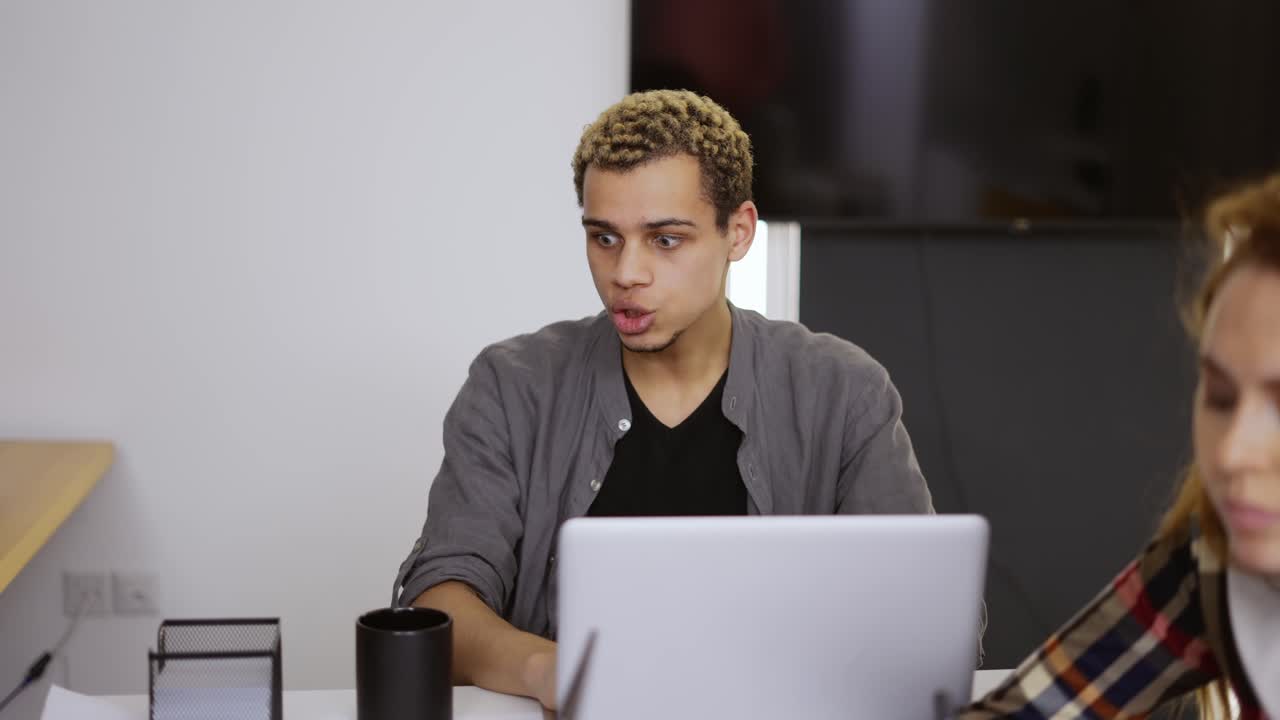 Young business coworkers in the office, mixed race man has a video conference