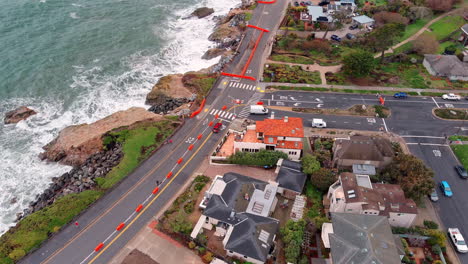 Repairing-scenic-West-Cliff-Drive-in-Santa-Cruz,-California-after-storm-damage---aerial-reveal