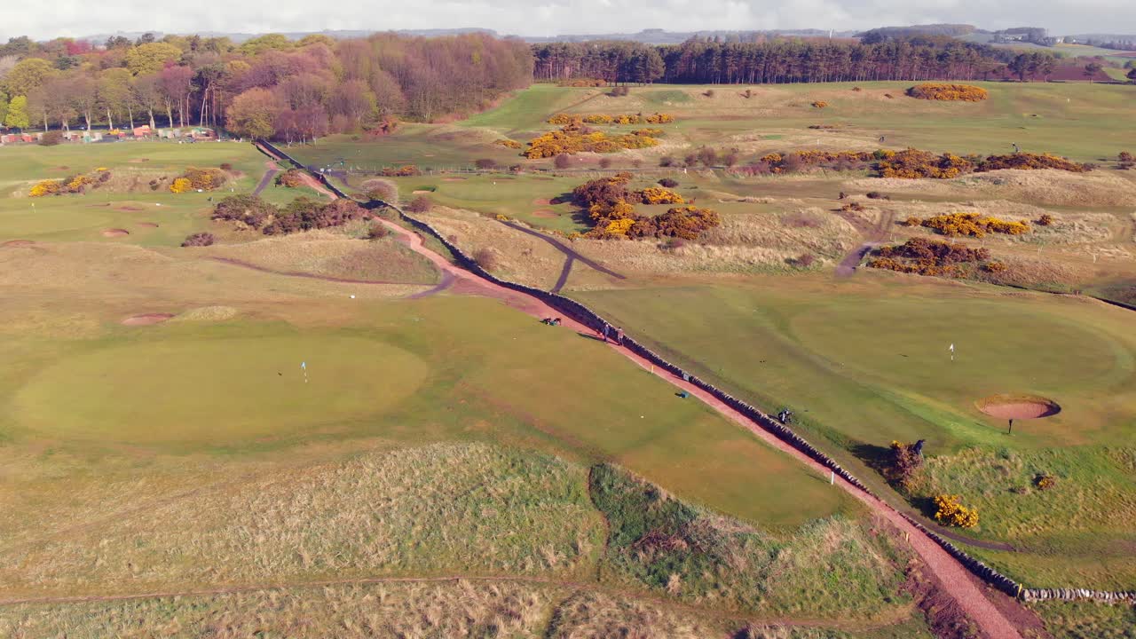 campo de golf escocés desde el aire con un camino que atraviesa un día soleado