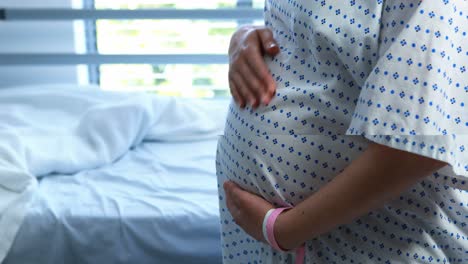 pregnant woman touching her belly in ward