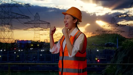 excited female engineer at power plant sunset