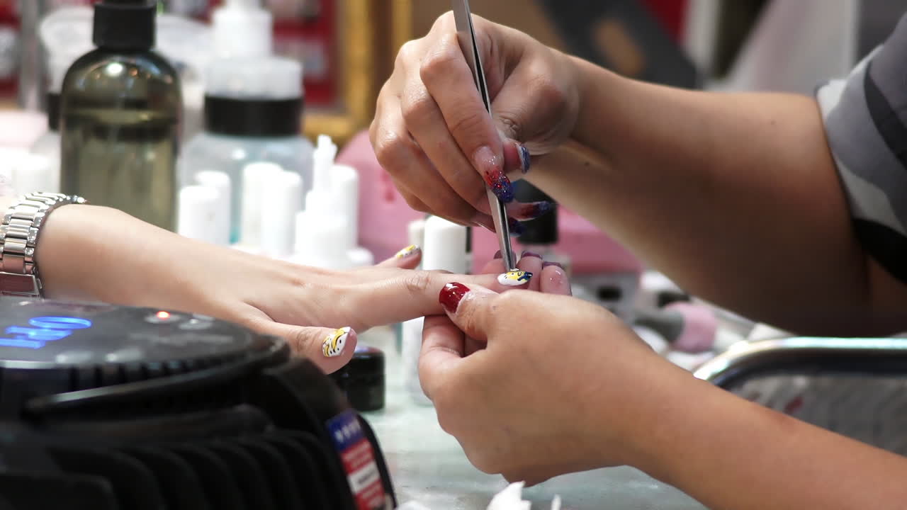 Close-up of a woman receiving a professional hand and nail manicure at a beauty salon. Focus on female hands, skincare, and nail care treatment