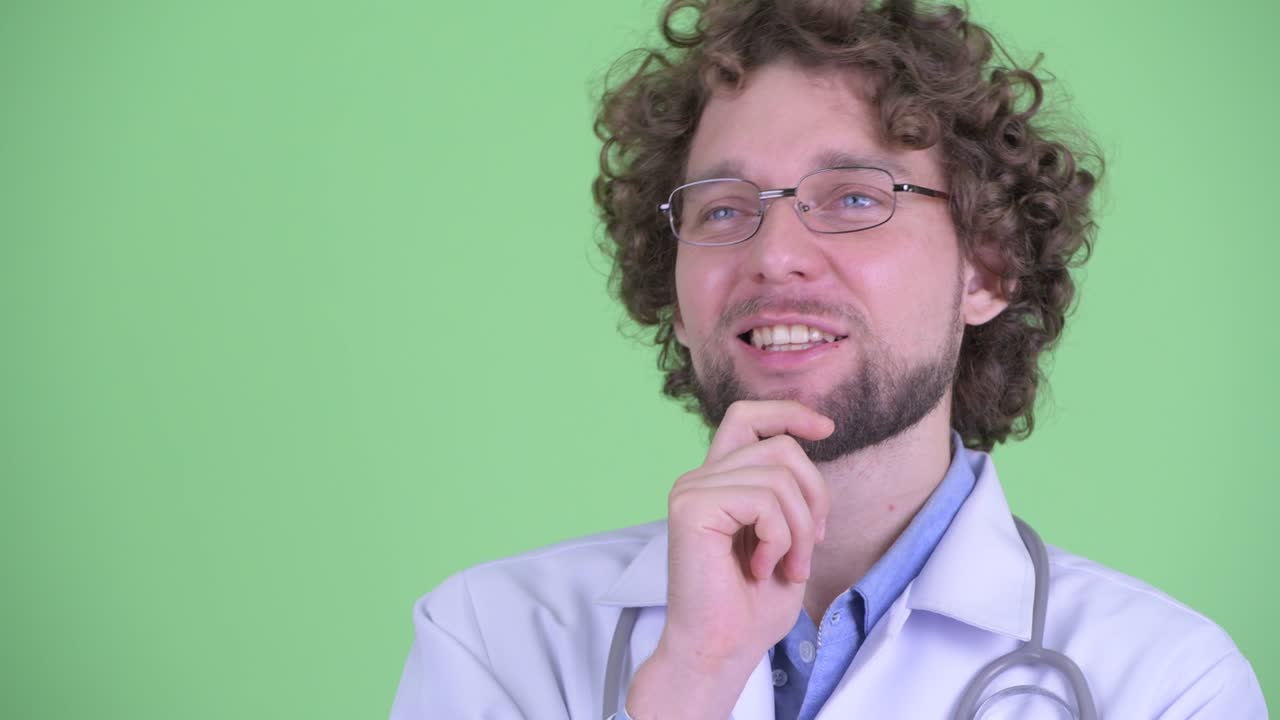 joven hombre guapo barbudo médico con cabello rizado