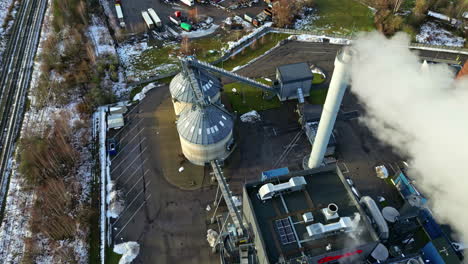 aerial panoramic overview of smoke exiting smokestack at refinery industrial park