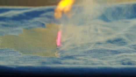 shot of laser burning of jeans in jeans making factory