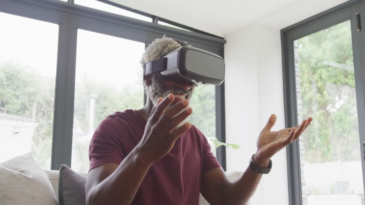 Video of african american senior man using vr headset