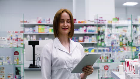 Blonde-Frau-Mit-Tablet-In-Einer-Apotheke