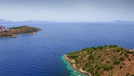 flying above wild rocky spit protruding into the sea, kargı koyu lagoon, datça