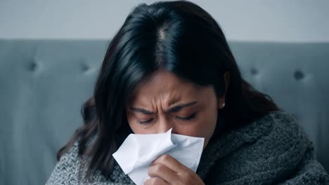 woman coughing and sneezing into a tissue