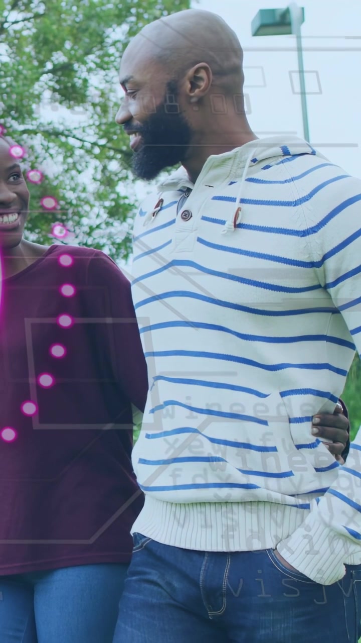 Vertical video: Duo walking in park camera panning causing pink tech overlay masking torso smiling